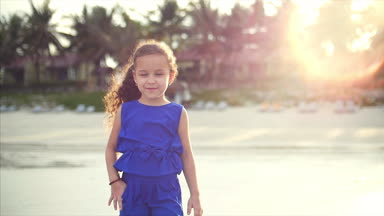 Okyanus sahil genç mutlu petite kız yürüyüş. Deniz kıyısı yürüyüş mutlu küçük kız mavi elbiseli, beyaz görünüm.
