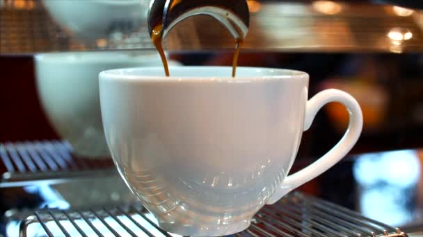 Кофе эспрессо приготовления, кофе эспрессо высшего качества итальянского производства с профессиональной кофеваркой падает в чашку кофе. Отснятый материал — стоковое видео