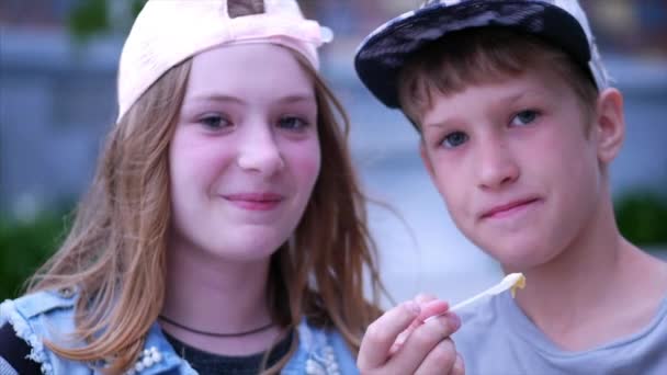 Fratello felice sorella nel parco, all'aperto a mangiare gelato. Fratello e sorella felici. Felice adolescente Famiglia . — Video Stock