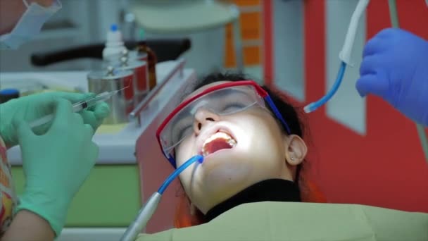 Dentista do sexo feminino a tratar os dentes dos pacientes na clínica. O dentista profissional feminino dá uma injeção em uma gengiva de paciente. Conceito de exame dentário . — Vídeo de Stock