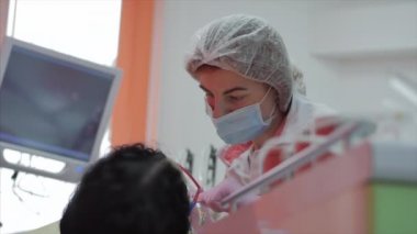 Kadın diş hekimi klinikte kadın hastayı tedavi ediyor. Kadın profesyonel doktor Stomatolog iş başında. Konsept Diş Denetimi.