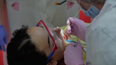 Kadın diş hekimi klinikte kadın hastayı tedavi ediyor. Kadın profesyonel doktor Stomatolog iş başında. Konsept Diş Denetimi.