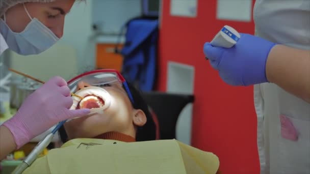 Mujer dentista tratando dientes a mujer paciente en clínica. Doctora Profesional Estomatóloga en el Trabajo. Concepto Dental Check Up. — Vídeo de stock