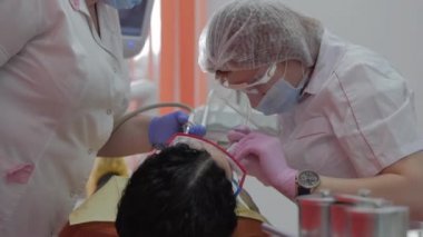 Kadın diş hekimi klinikte kadın hastayı tedavi ediyor. Kadın profesyonel doktor Stomatolog iş başında. Konsept Diş Denetimi.