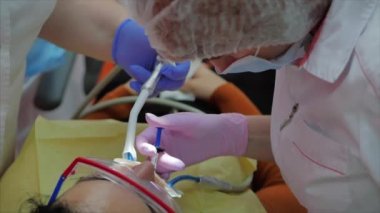Kadın diş hekimi klinikte kadın hastayı tedavi ediyor. Kadın profesyonel doktor Stomatolog iş başında. Konsept Diş Denetimi.