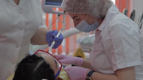 Kvinna tandläkare behandla tänder till kvinna patient på kliniken. Kvinnlig professionell läkare Stomatolog på jobbet. Koncept Tandkontroll. — Stockvideo