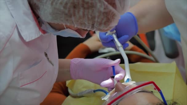 Tandarts trakteert vrouwen op een patiënt in de kliniek. Vrouwelijke professionele dokter Stomatoloog op het werk. Concept Tandheelkundige controle. — Stockvideo