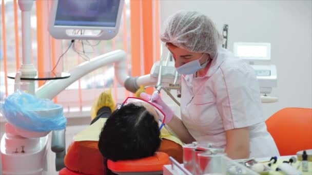 Tandarts trakteert vrouwen op een patiënt in de kliniek. Vrouwelijke professionele dokter Stomatoloog op het werk. Concept Tandheelkundige controle. — Stockvideo