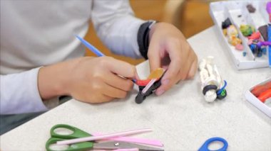Çocuk elleri, yakın plan çocuklar, masada plastik kaplamalardan heykeller, çizim ve heykel için çocuklar gelişim çemberi. 5-7 yaşlarındaki çocukların gelişim süreci.