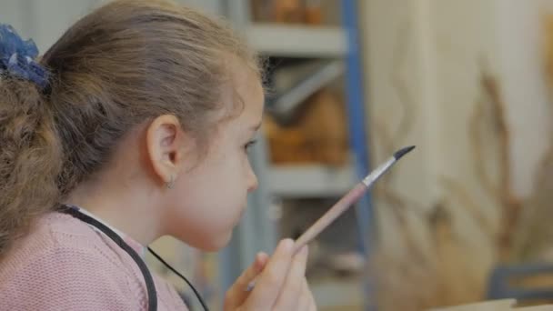 Young Hands of the Artist, Little Woman Artist målar en duk med borste, sitter ett bord och ritar på duk. Process att rita: i konstnärer Art Studio Hand Baby Girl Sketching på duk. — Stockvideo