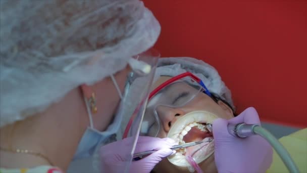 Mujer dentista tratando dientes a mujer paciente en clínica. Doctora Profesional Estomatóloga en el Trabajo. Concepto Dental Check Up. — Vídeo de stock