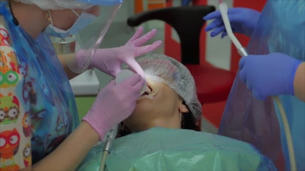 Dentystka lecząca zęby pacjentce w klinice. Higiena jamy ustnej ze specjalnym roztworem, czyszczenie jamy ustnej ultradźwiękiem. Lekarz dentysta w pracy. Badanie stomatologiczne — Wideo stockowe