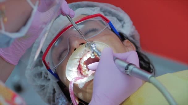 Tandarts trakteert vrouwen op een patiënt in de kliniek. Vrouwelijke professionele dokter Stomatoloog op het werk. Concept Tandheelkundige controle. — Stockvideo