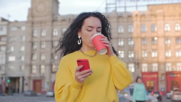Mulher Jovem Muçulmana Caminhando no Centro da Cidade, Usando Smartphone e Bebendo Café. Conceito Comunicação, compras online, Bom Humor, Emoções Positivas . — Vídeo de Stock