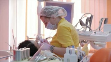 Kadın diş hekimi klinikte kadın hastayı tedavi ediyor. Kadın profesyonel doktor Stomatolog iş başında. Konsept Diş Denetimi.