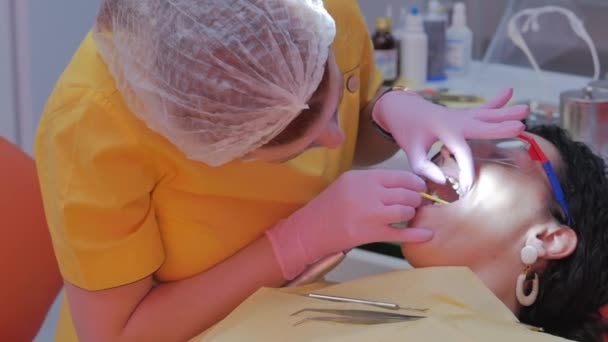 Tandarts trakteert vrouwen op een patiënt in de kliniek. Vrouwelijke professionele dokter Stomatoloog op het werk. Concept Tandheelkundige controle. — Stockvideo