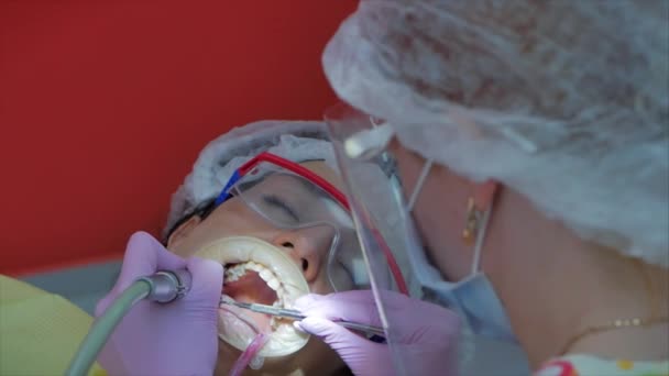 Mujer dentista tratando dientes a mujer paciente en clínica. Doctora Profesional Estomatóloga en el Trabajo. Concepto Dental Check Up. — Vídeo de stock