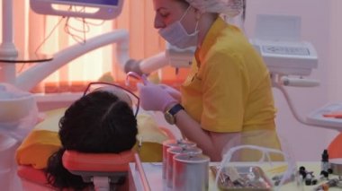 Kadın diş hekimi klinikte kadın hastayı tedavi ediyor. Kadın profesyonel doktor Stomatolog iş başında. Konsept Diş Denetimi.
