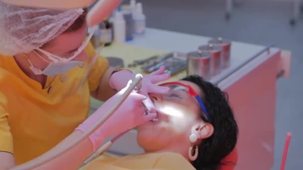 Mujer dentista tratando dientes a mujer paciente en clínica. Doctora Profesional Estomatóloga en el Trabajo. Concepto Dental Check Up. — Vídeo de stock