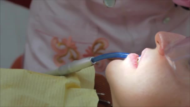 Close-up vrouw tandarts behandelen van tanden aan vrouw patiënt in de kliniek. Vrouwelijke professionele dokter Stomatoloog op het werk. Concept Tandheelkundige controle. — Stockvideo