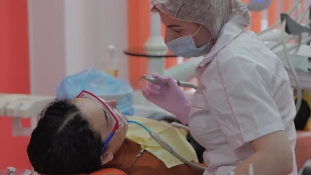 Mujer dentista tratando dientes a mujer paciente en clínica. Doctora Profesional Estomatóloga en el Trabajo. Concepto Dental Check Up. — Vídeos de Stock