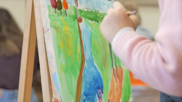 Young Hands of the Artist, Little Girl Artist Paint a Canvas with Brush, Sitting a Table and Draw on Canvas. Proces van tekenen: in Artiesten Art Studio Hand Baby Girl Schetsen op doek. — Stockvideo