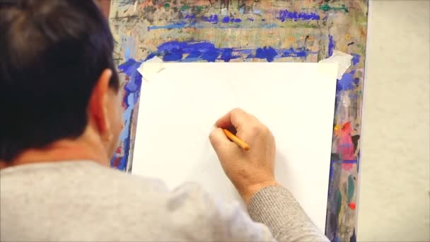 Ritningsprocess: i konstverkstaden. Händerna på konstnären, en kvinnlig konstnär målar. Skiss på duk. — Stockvideo