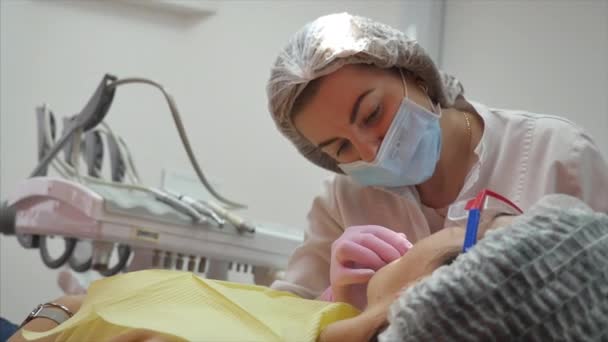 Odontoiatra professionista al lavoro che effettua un trattamento dentale.Odontoiatra donna che cura i denti alla paziente donna in clinica. Esame dentale . — Video Stock