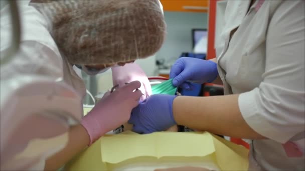 Dentista médico mulher profissional no trabalho, tratando os dentes para paciente mulher na clínica. Médica estomatologista profissional no trabalho. Equipamento dentário em segundo plano . — Vídeo de Stock