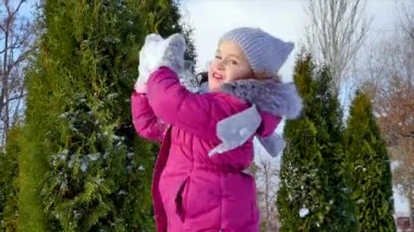 Güneşli bir kış gününde mutlu, eğlenceli bir çocukluk. Kız, babasıyla kartopu oynarken, kameraya bir kar küresi fırlatıyor, hem eğleniyor hem de gülümsüyor..