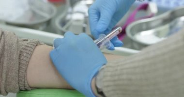 Aşıyı yakından çekince, hemşire hastaya damardan ilaç veriyor. Doktor damardan kan alır ya da enjekte eder..