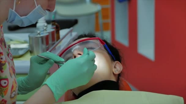 Zubařka ošetřující zuby pacientce na klinice. Profesionální doktorka Stomatoložka v práci. Zubní prohlídka konceptu. — Stock video