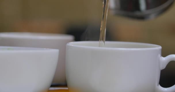 Té de la tetera se vierte lentamente en una taza de porcelana . — Vídeos de Stock