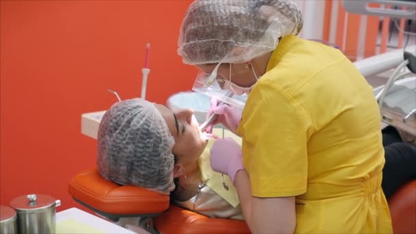 歯医者で口腔の健康診断と治療を受けています。女性歯科医クリニックで女性患者に歯を治療します.女性｜Professional Doctor Stomatologist at Work. — ストック動画