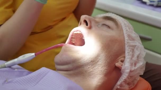 Close-up Vrouwelijke handen Professionele dokter Stomatoloog op het werk. Persoon ondergaat een medisch onderzoek en behandeling van de mondholte bij de tandarts. — Stockvideo