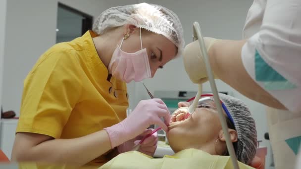 Close Up mani femminili Medico Stomatologo professionista sul lavoro. Persona sottoposta a esame medico e trattamento della cavità orale presso il dentista . — Video Stock