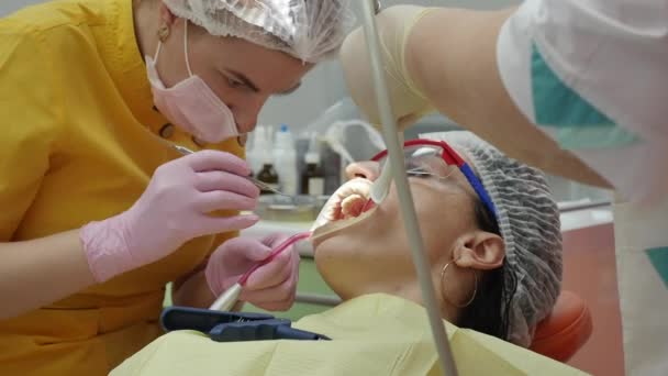 Närbild Kvinnliga händer Professionell läkare Stomatolog på jobbet. Person genomgår en medicinsk undersökning och behandling av munhålan hos tandläkaren. — Stockvideo