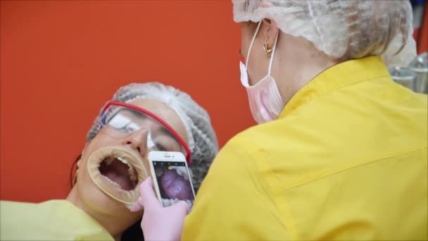Professionelle Zahnarzt am Arbeitsplatz fotografiert Zähne nach der Behandlung. eine Person unterzieht sich einer ärztlichen Untersuchung und Behandlung der Mundhöhle beim Zahnarzt. — Stockvideo