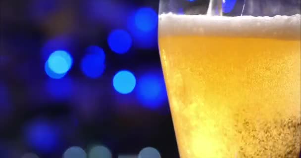 Verre de champagne ou de bière dans un verre sur le fond des lumières de vacances ou du Nouvel An, sur un beau fond bière fraîche, bière froide légère dans un verre avec des gouttes d'eau. Fraicheur et mousse. 4K — Video