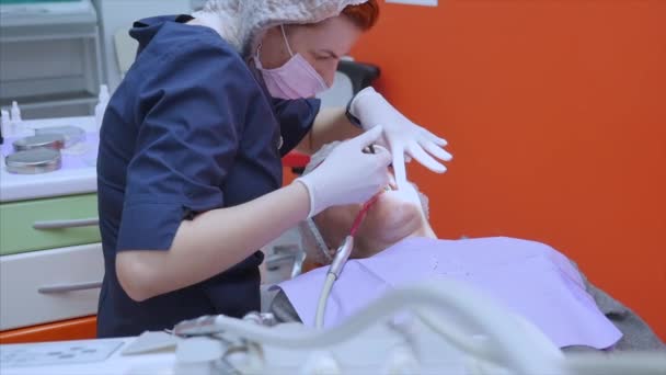 O médico ou dentista faz uma injeção com uma seringa, injeta uma preparação de cálcio com o paciente diretamente no canal dentário . — Vídeo de Stock