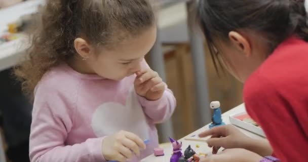 Roztomilé malé děti sedí u psacího stolu Sculpts a Different Figures From Made of Colored Modeling Plasticine in the Nursery. Vývoj umění modelování u dětí. — Stock video