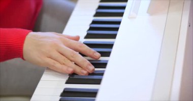Kadın ya da kız A öğrencisi ya da profesyonel piyanist güzel beyaz bir piyanoda klasik müzik çalar. Yavaş çekimde piyanistin elleri. Piyano tuşları koyu renklerde kapanır. 4k