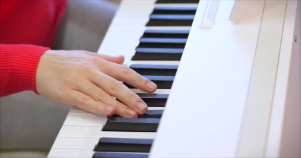 Kobieta lub dziewczyna Student lub zawodowy pianista gra muzykę klasyczną na pięknym białym fortepianie, ręce pianisty zbliżenie w zwolnionym tempie. Klucze fortepianowe zamykają się w ciemnych kolorach. 4k — Wideo stockowe