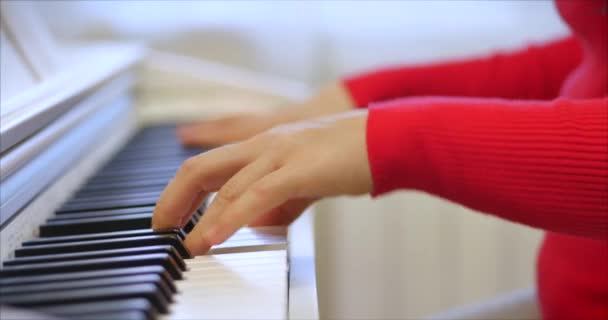 Kadın ya da kız A öğrencisi ya da profesyonel piyanist güzel beyaz bir piyanoda klasik müzik çalar. Yavaş çekimde piyanistin elleri. Piyano tuşları koyu renklerde kapanır. 4k — Stok video