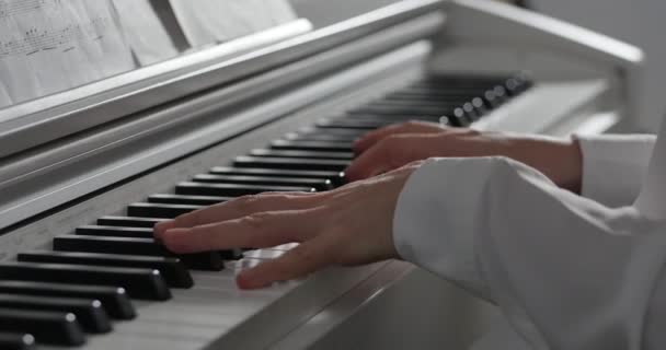 Donna o ragazza Uno studente o pianista professionista suona musica classica su un bel pianoforte bianco, mani di un pianista primo piano al rallentatore. Tasti di pianoforte da vicino in colori scuri. 4K — Video Stock