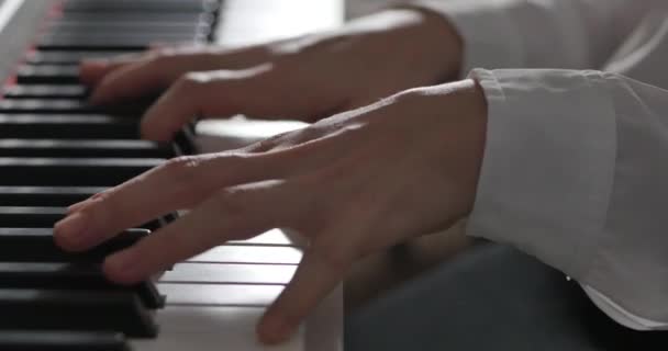 Femme ou fille Un étudiant ou pianiste professionnel joue de la musique classique sur un beau piano blanc, les mains d'un pianiste gros plan au ralenti. Clés de piano se ferment dans des couleurs sombres. 4K — Video