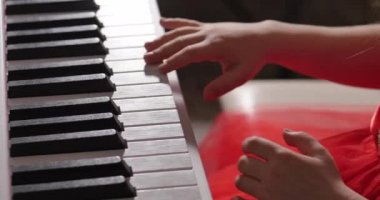 Küçük Bebek Kız ya da Çocuk Profesyonel Piyanist Güzel Beyaz Piyano 'da Klasik Müzik çalar Noel ağacının arka planına karşı bir Noel Tatili ve yanıp sönen yeni yıl ışıkları. Piyanistlerin elleri