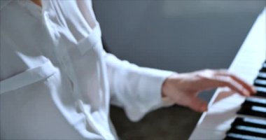 Kadın ya da kız A öğrencisi ya da profesyonel piyanist güzel beyaz bir piyanoda klasik müzik çalar. Yavaş çekimde piyanistin elleri. Piyano tuşları koyu renklerde kapanır. 4k