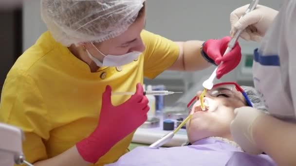 Arzt oder Zahnarzt spritzt eine Spritze, spritzt mit dem Patienten ein Kalziumpräparat direkt in den Zahnkanal. — Stockvideo