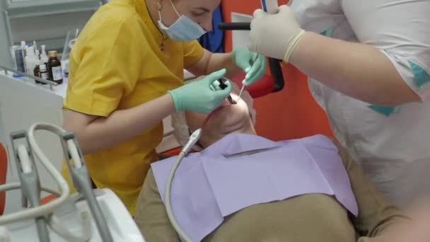 Doctor Estomatólogo en el Trabajo. La persona se somete a un examen médico y tratamiento de la cavidad oral en el dentista . — Vídeo de stock